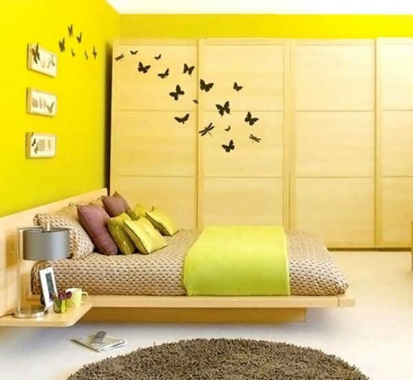 sunny-yellow-wall-bedroom-decoraation-with-wooden-bed-platform-and-wooden-cabinet-915x843